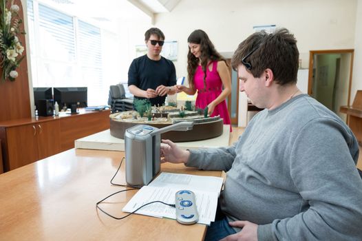 A visually impaired man uses a scanning and reading machine