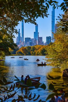 Image of New York City Central Park pond with boats and large city buildings in background