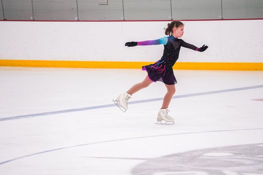 Little girl practicing before her figure skating competition at the indoor ice rink.