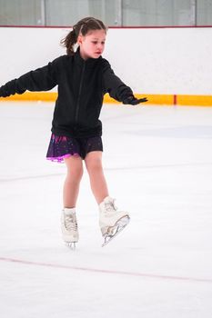 Little girl practicing before her figure skating competition at the indoor ice rink.