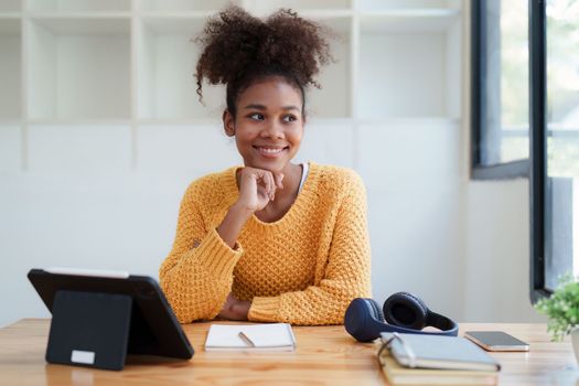 Young black curly hair american african woman using digital tablet.