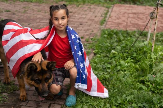 Happy adorable little girl smiling and waving American flag outside, her dress with strip and stars, cowboy hat. Smiling child celebrating 4th july - Independence Day. High quality photo