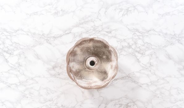 Flat lay. Greasing bunt cake pan to bake chocolate pumpkin bundt cake with toffee glaze.