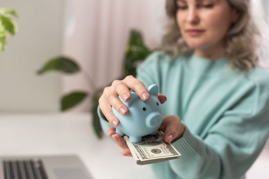 Young woman planning save salary money early years using laptop computer with pig bank save coin