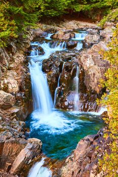 Image of Beautiful blue waterfalls pouring into buckets of rock with forest around