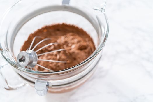 Whipping chocolate ganache with an electric kitchen mixer.
