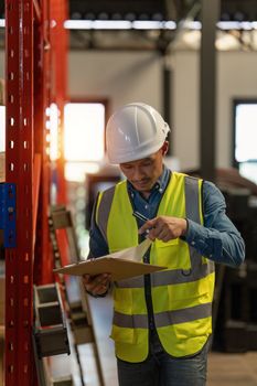 Working at warehouse. Male warehouse worker checking in storage department. Employee organizing goods distribution to the market