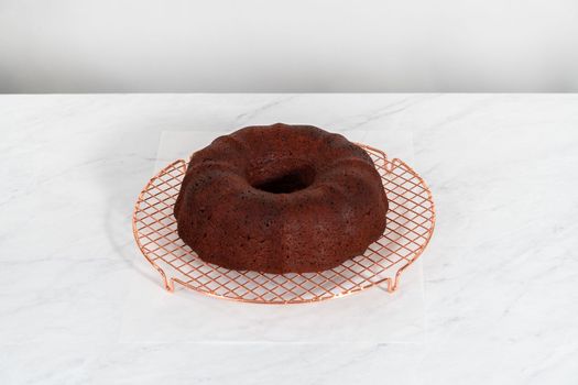 Cooling freshly baked red velvet bundt cake on a kitchen counter.