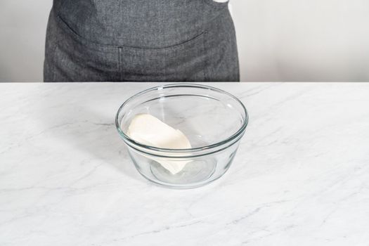 Mixing ingredients in a large glass mixing bowl to make the cream cheese filling for bundt cake.