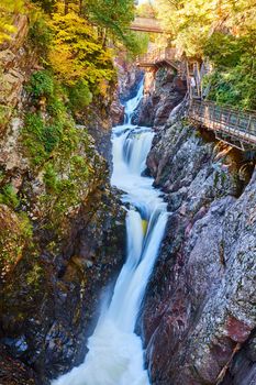 Image of Fall forest and cliffs with tiers of heavy waterfall rapids with boardwalk built into rocks