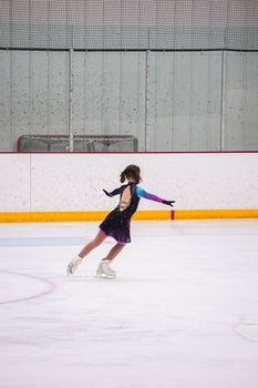 Little girl practicing before her figure skating competition at the indoor ice rink.
