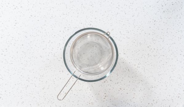 Flay lay. Draining browned ground turkey through a fine mesh strainer.