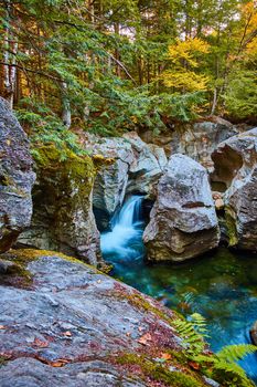 Image of Stunning rocks with river carving gorges by waterfall into blue waters surrounded by mossy forest