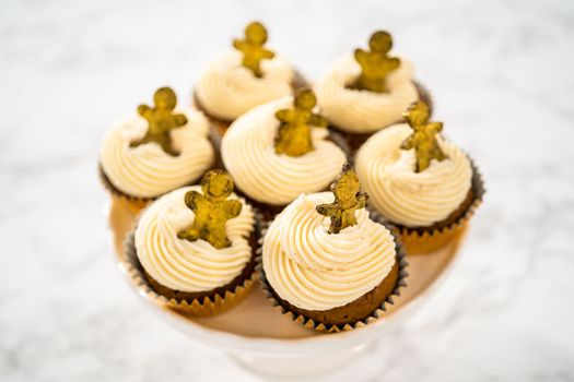 Freshly baked gingerbread cupcakes with eggnog buttercream frosting and topped with a gingerbread man.