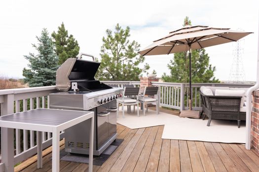 Outdoor six-burner gas grill on the back patio of a luxury single-family home.
