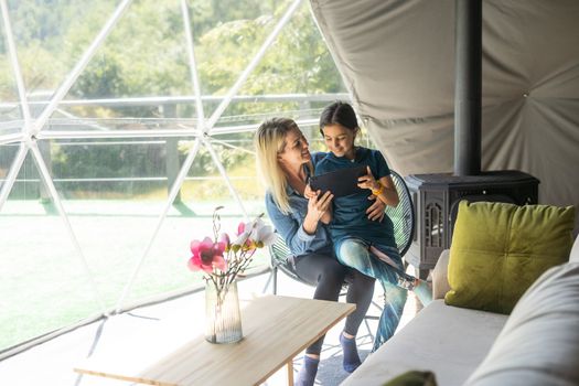 Mother and daughter playing with digital tablet.