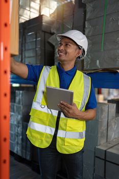 Working at warehouse. Male warehouse worker checking in storage department. Employee organizing goods distribution to the market