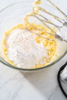Mixing ingredients in a large glass mixing bowl to make the cream cheese filling for bundt cake.