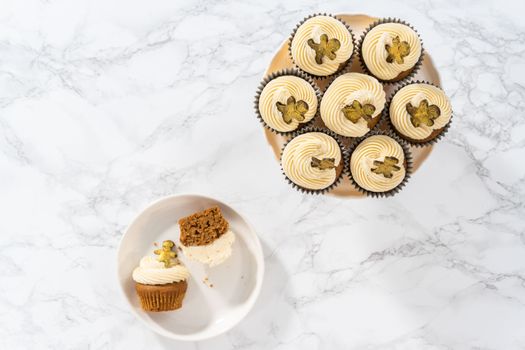 Eating freshly baked gingerbread cupcakes with eggnog buttercream frosting and topped with a gingerbread man.