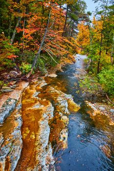 Image of Beautiful river in peak fall with exposed rocks and vibrant leaves