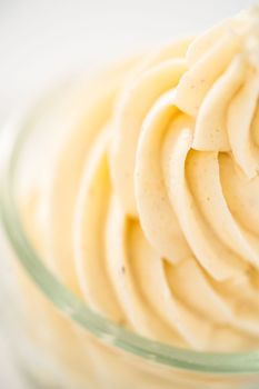 Swirl of eggnog buttercream frosting in a small glass bowl.