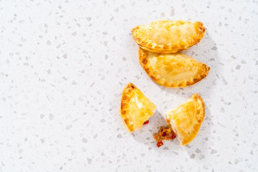 Freshly baked turkey empanadas on the kitchen counter.