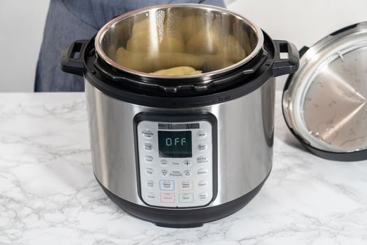 Mashed potatoes. Cooking whole peeled potatoes in a pressure cooker to make mashed potatoes.