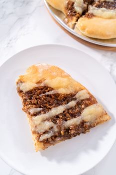 Freshly baked cinnamon dessert pizza with cream cheese drizzle.