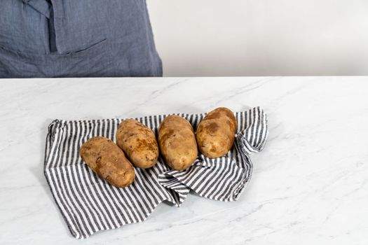 Pressure Cooker Baked Potatoes. Drying washed raw potatoes with a kitchen towel.