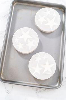 Filling silicone mold with white melted chocolate to make chocolate chocolate stars for American flag mini cupcakes.