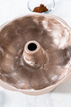 Greasing metal bundt cake pan to red velvet bundt cake with cream cheese glaze.