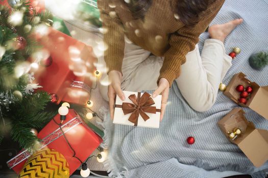 Cheerful lady surprised of the present after the opening in the gift box. Marry Christmas and Happy Holidays and New Year eve celebrating concept.