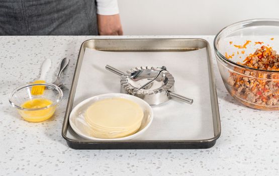 Flat lay. Filling empanada dough with turkey filling to make turkey empanadas.