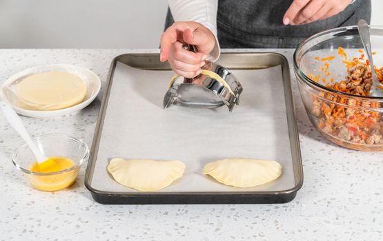 Flat lay. Filling empanada dough with turkey filling to make turkey empanadas.