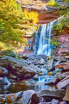 Image of Looking up towards layers of cascading waterfalls over rocky cliffs during fall in golden light of New York