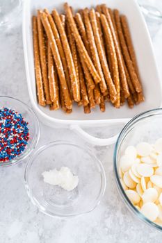 Ingredients in glass mixing bowls to prepare chocolate dipped pretzel rods for the July 4th celebration.