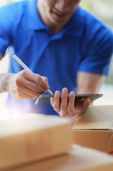 Asian courier with parcel and delivery logistic concept. Delivery man using digital tablet.