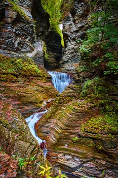 Image of Waterfall through gorge with terraced rock and fall leaves