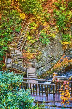 Image of Endless boardwalk stairs across river and up cliffs surrounded by fall foliage