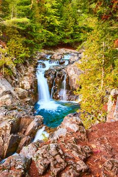 Image of Forest surrounds peaceful blue waterfalls into rocky canyon