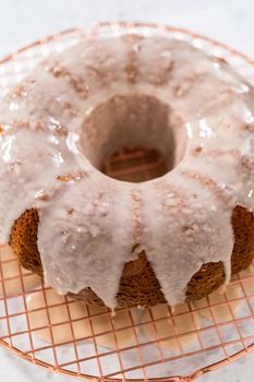 Glazing vanilla bundt cake with a white vanilla glaze.