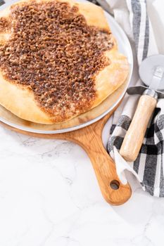 Freshly baked cinnamon dessert pizza with cream cheese drizzle.