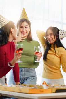 Friends at birthday party clinking glasses with champagne and pizza, enjoying christmas vacation, pizza on the table. Holiday Party event.