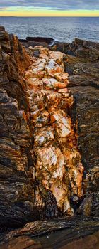 Image of Large mineral quartz vein in rocky Maine coast detail with ocean in background