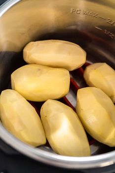 Mashed potatoes. Cooking whole peeled potatoes in a pressure cooker to make mashed potatoes.