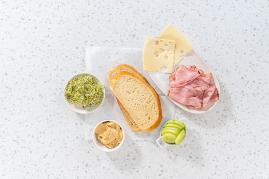 Flat lay. Measured ingredients in glass mixing bowls to make ham, cucumber, and sprout sandwiches.