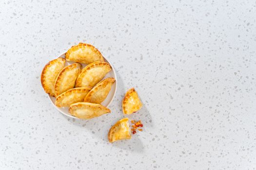 Flat lay. Freshly baked turkey empanadas on the kitchen counter.