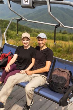 man and woman on the lift in the mountains