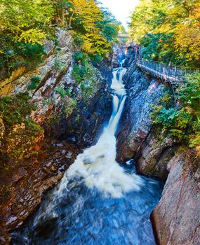 Image of Stunning rocky canyon gorge in fall with boardwalk along cliffs and cascading waterfalls pouring through