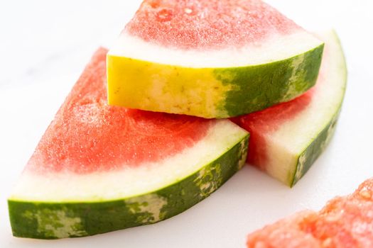 Slicing riped red watermelon to prepare chili lime watermelon pops.